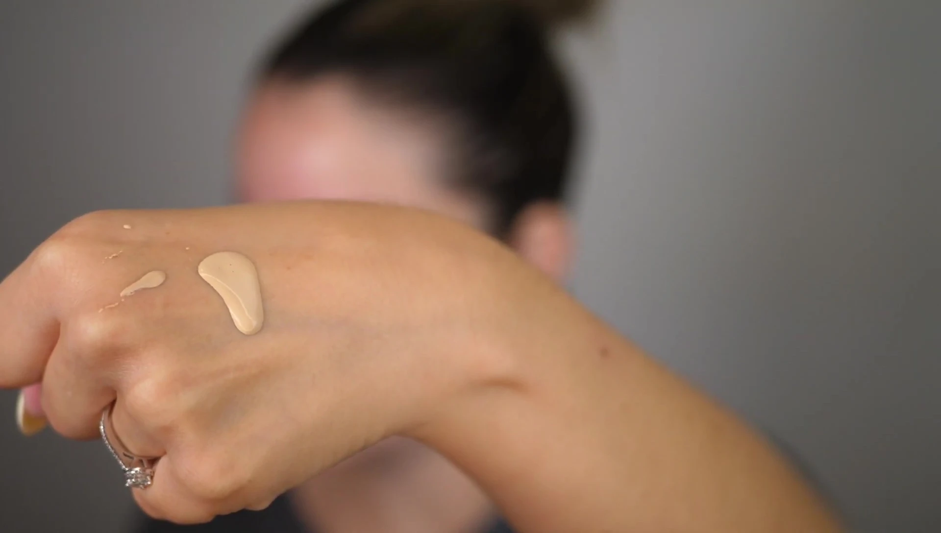 The foundation being dispensed onto the back of the hand