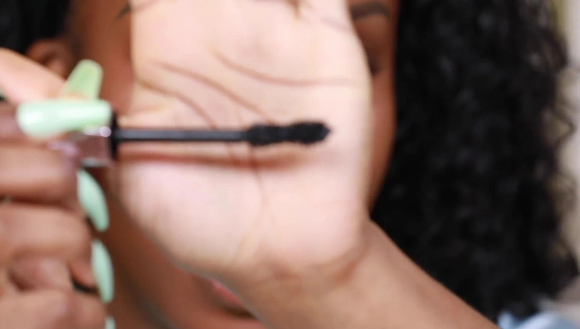 Close-up of the mascara wand, highlighting its unique dual-fiber design and curvy shape.