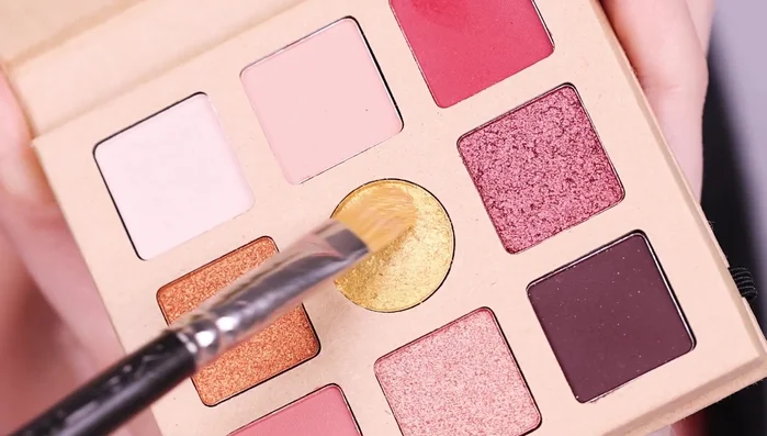 Apply golden eyeshadow all over the eyelid using a flat brush.