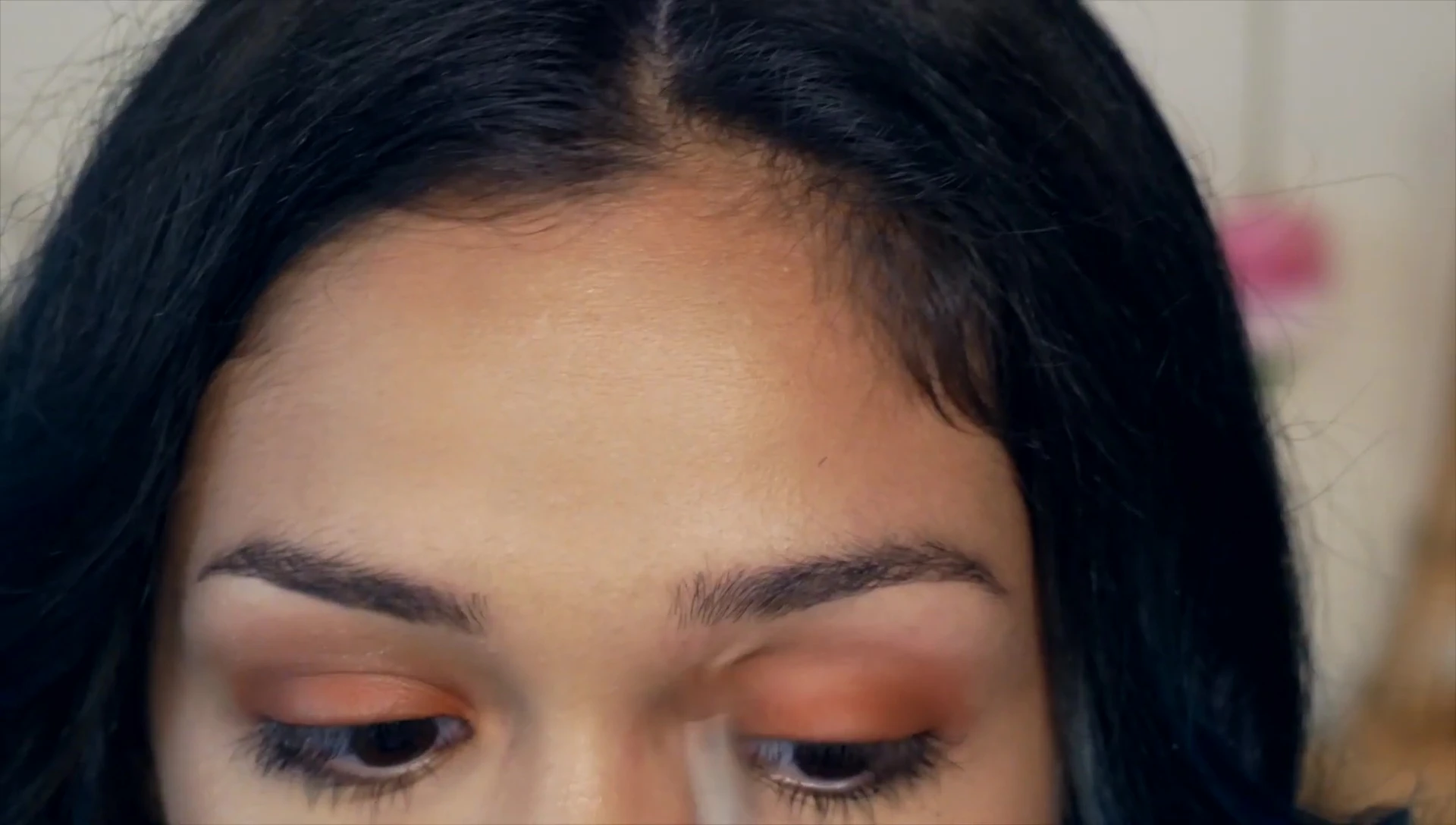 The creator applying eyeshadow to their eye
