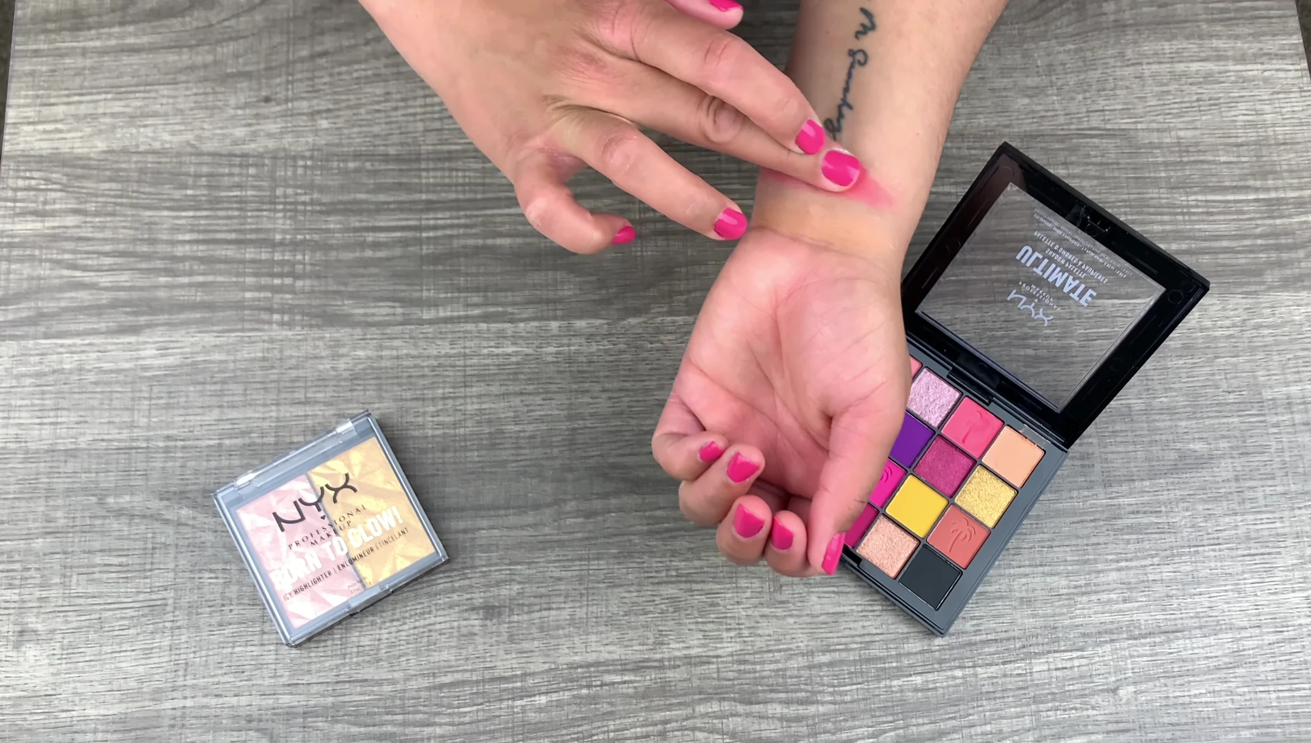 Close-up of eyeshadow swatches on the reviewer's arm.