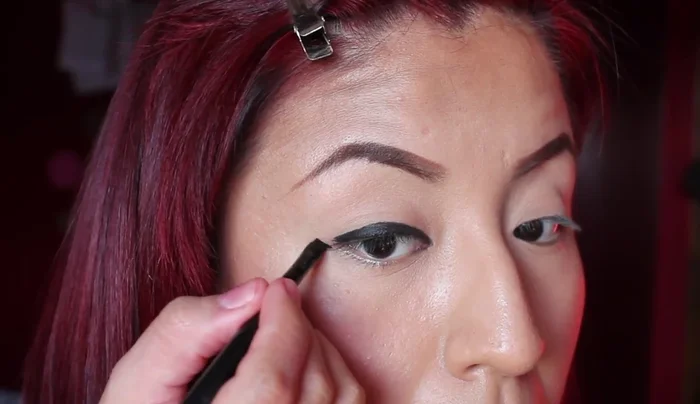 Create a line using the tip of the angled brush, connecting it with the eyeliner. Fill it in gently, using the tip of the angled brush.