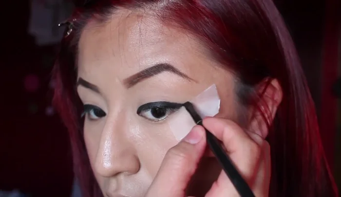 Extend the eyeliner towards the end. You don't have to be cautious because you're using tape.