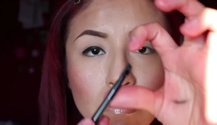 Grab more eyeliner and use the tip of the brush to create a line, using your lower lid as a guideline. Connect it towards your brow.