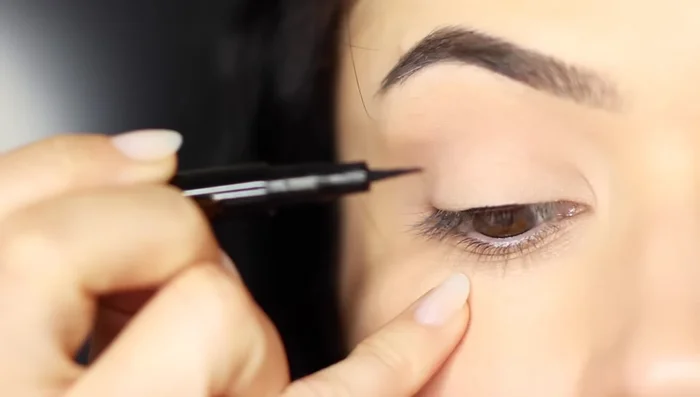 Fold your pinky underneath to get closer access to the outer corner, or switch hands and pull the liner from the outer edge into the center.