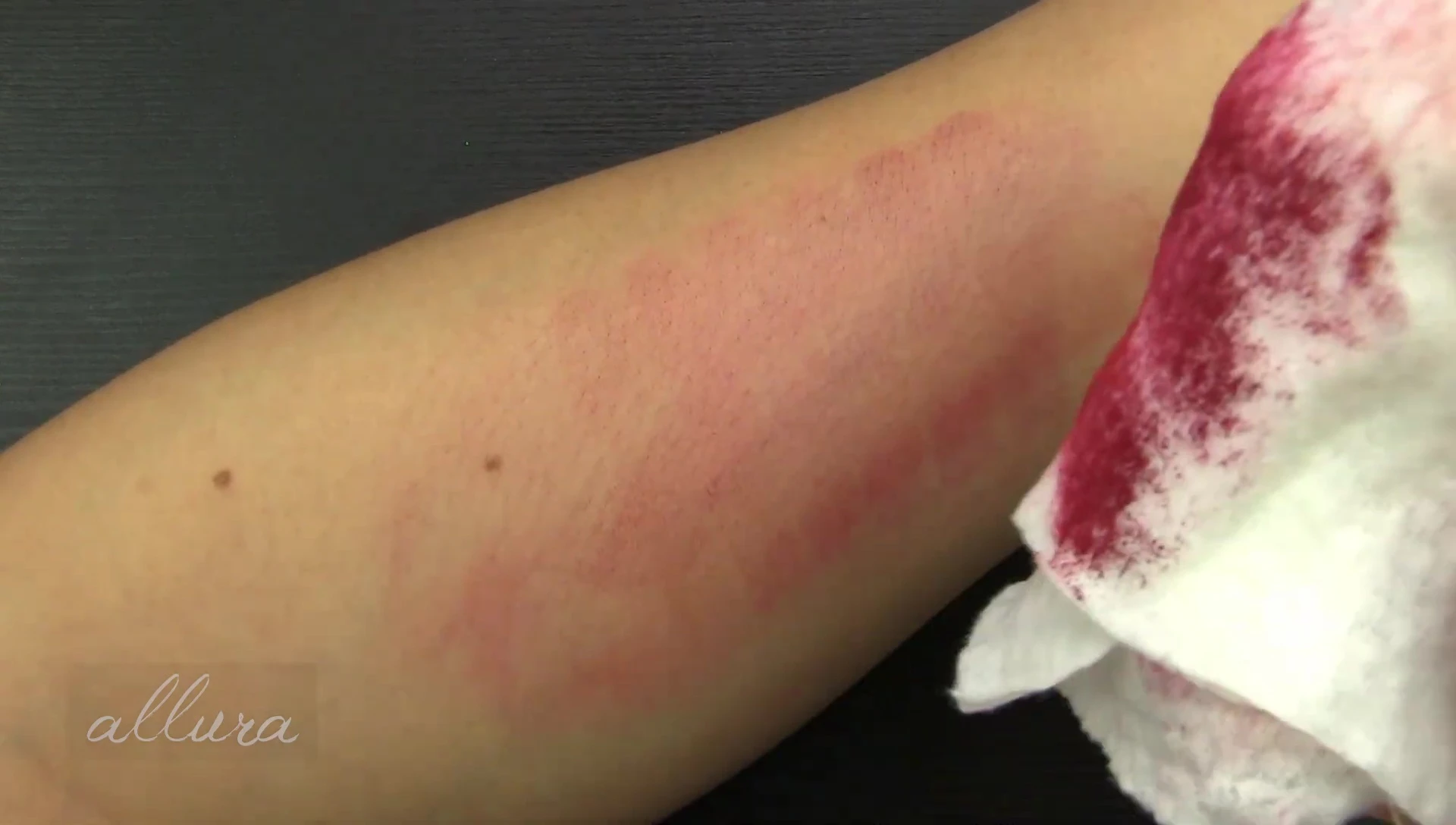Close-up showing lipstick staining on the skin after wipe.