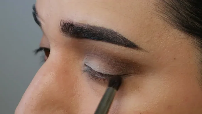 Add a dark color (e.g., black) in a triangle shape to the outer corner of the eyelid using a small, pointed pencil brush.
