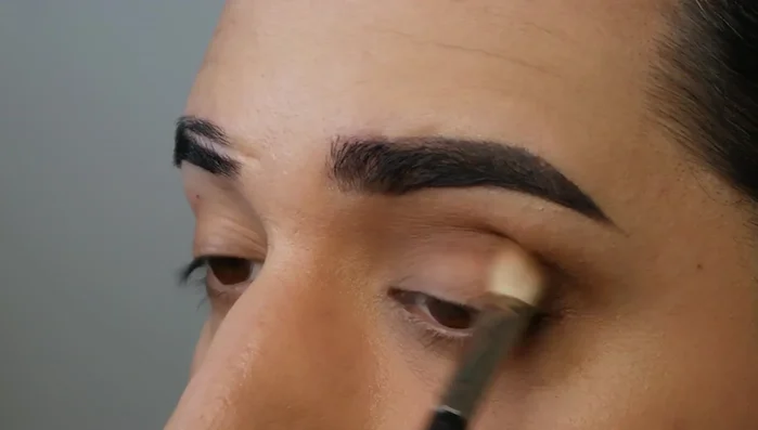 Buff out the deeper eyeshadow with a fluffy brush.