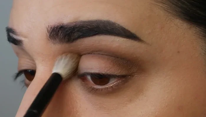 Buff out the deeper eyeshadow with a fluffy brush.