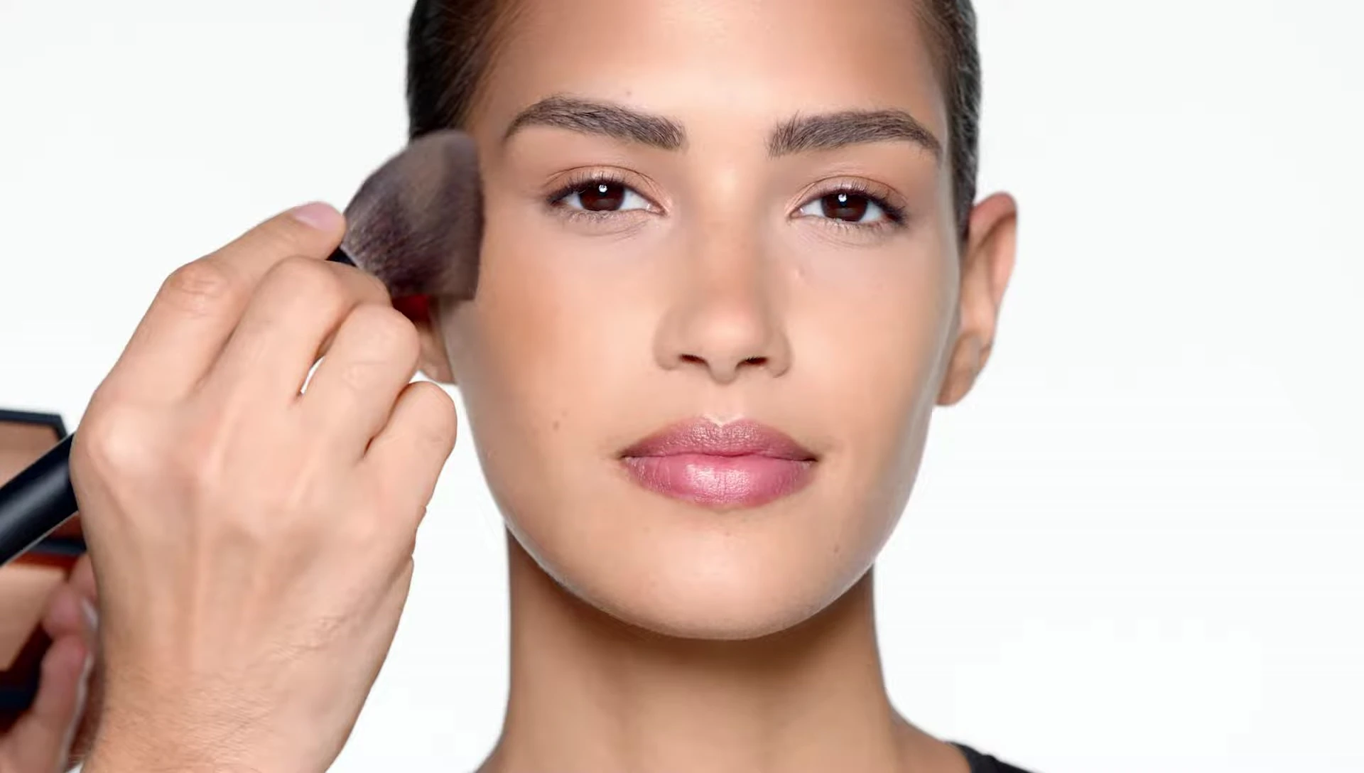 The model's face after applying the bronzer, showing a natural glow.