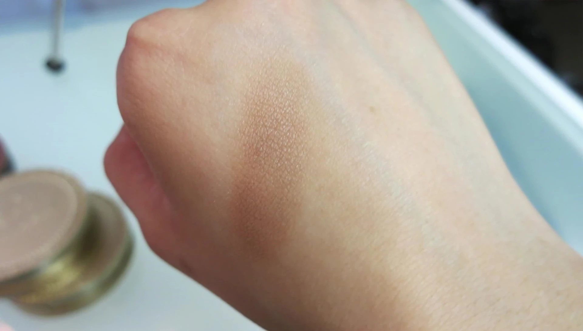 The reviewer highlighting the matte finish of the bronzer.