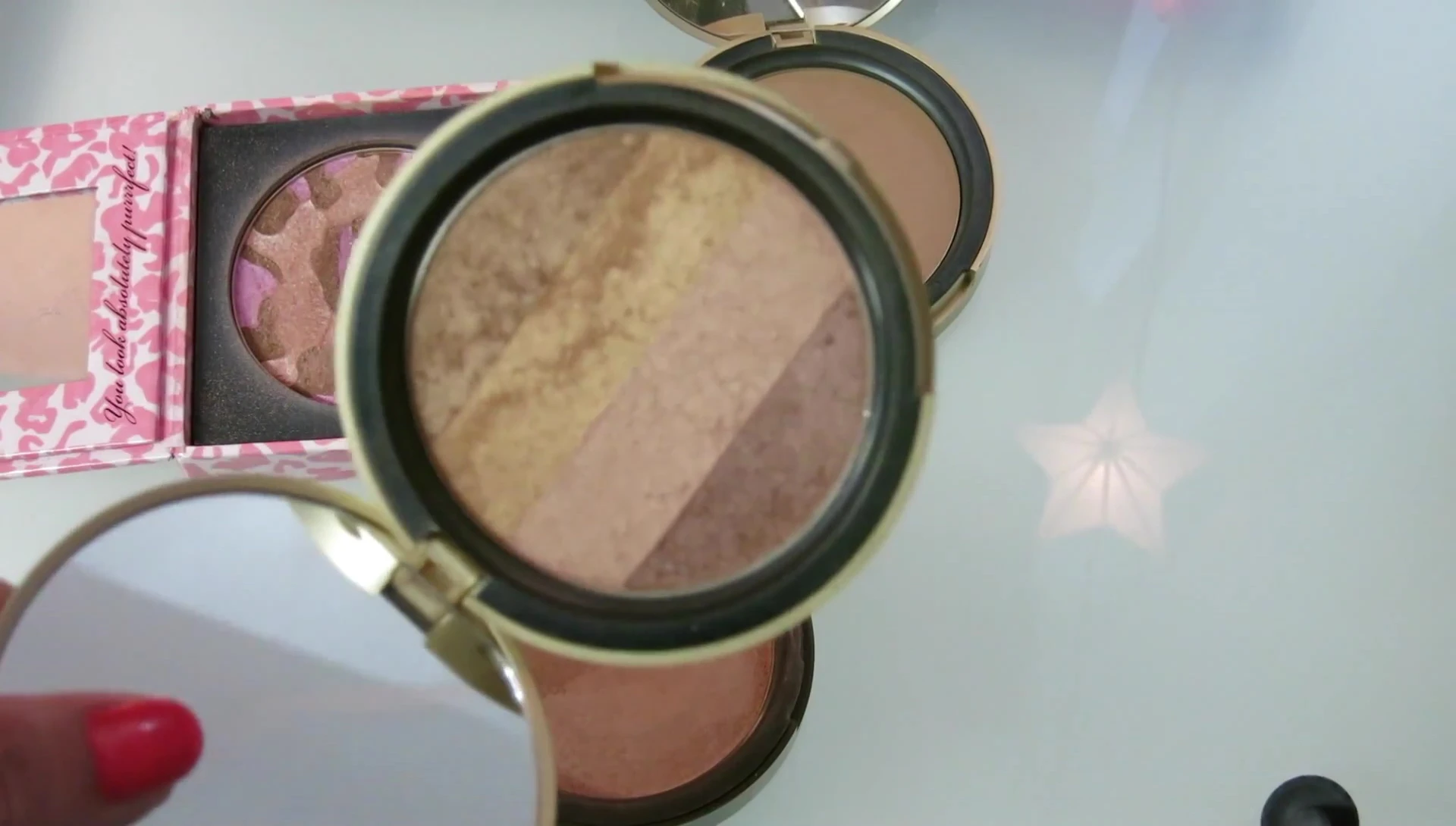 The reviewer showing the Too Faced Natural Love Flush bronzer.