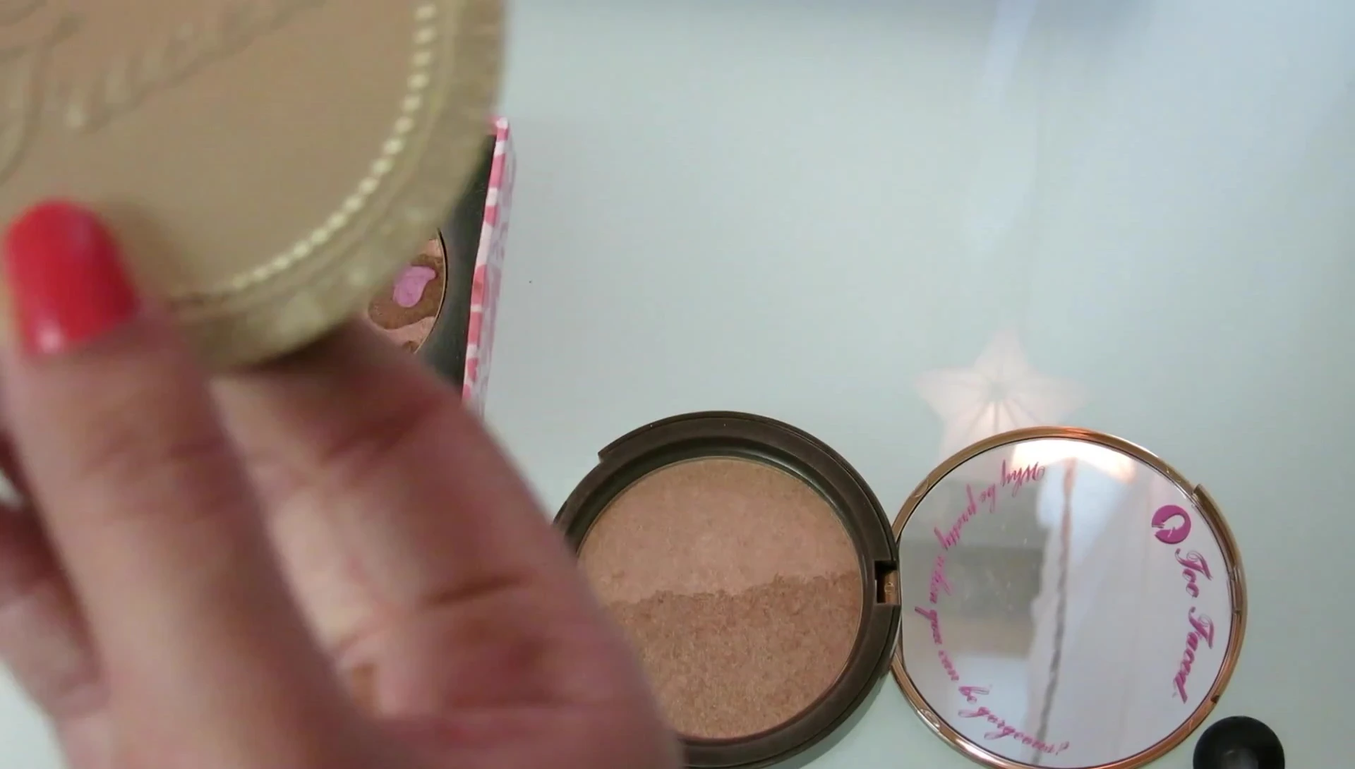 The reviewer holding the Too Faced Chocolate Soleil bronzer.