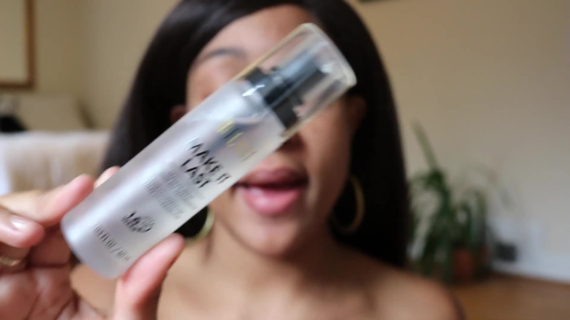 Screenshot showing the reviewer holding the Milani Make It Last spray.