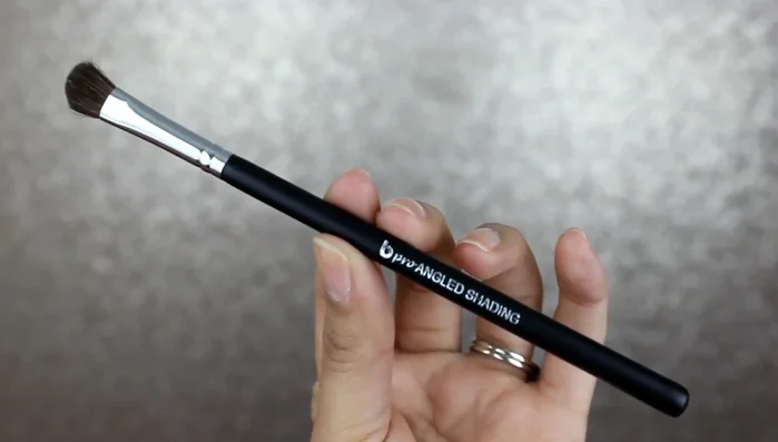 Apply “Nude Peach” eyeshadow to the brow bone using the Pro angled shading brush with soft sweeping motions.