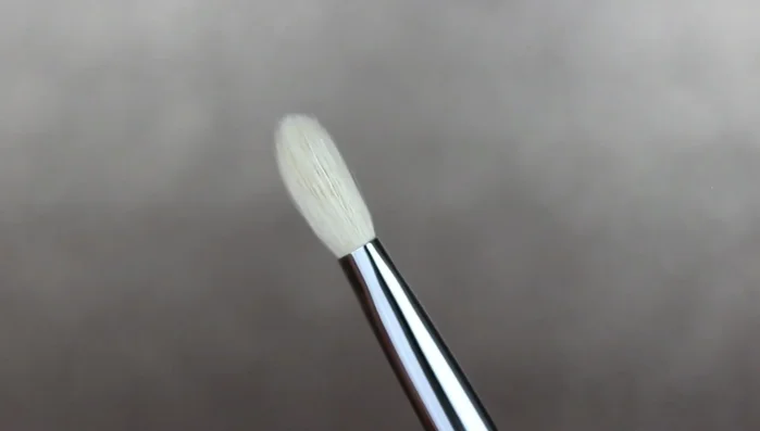 Apply “Peach Tea” eyeshadow to the outer corner (outer V) of the eye using the pro blending brush, gently patting and blending.