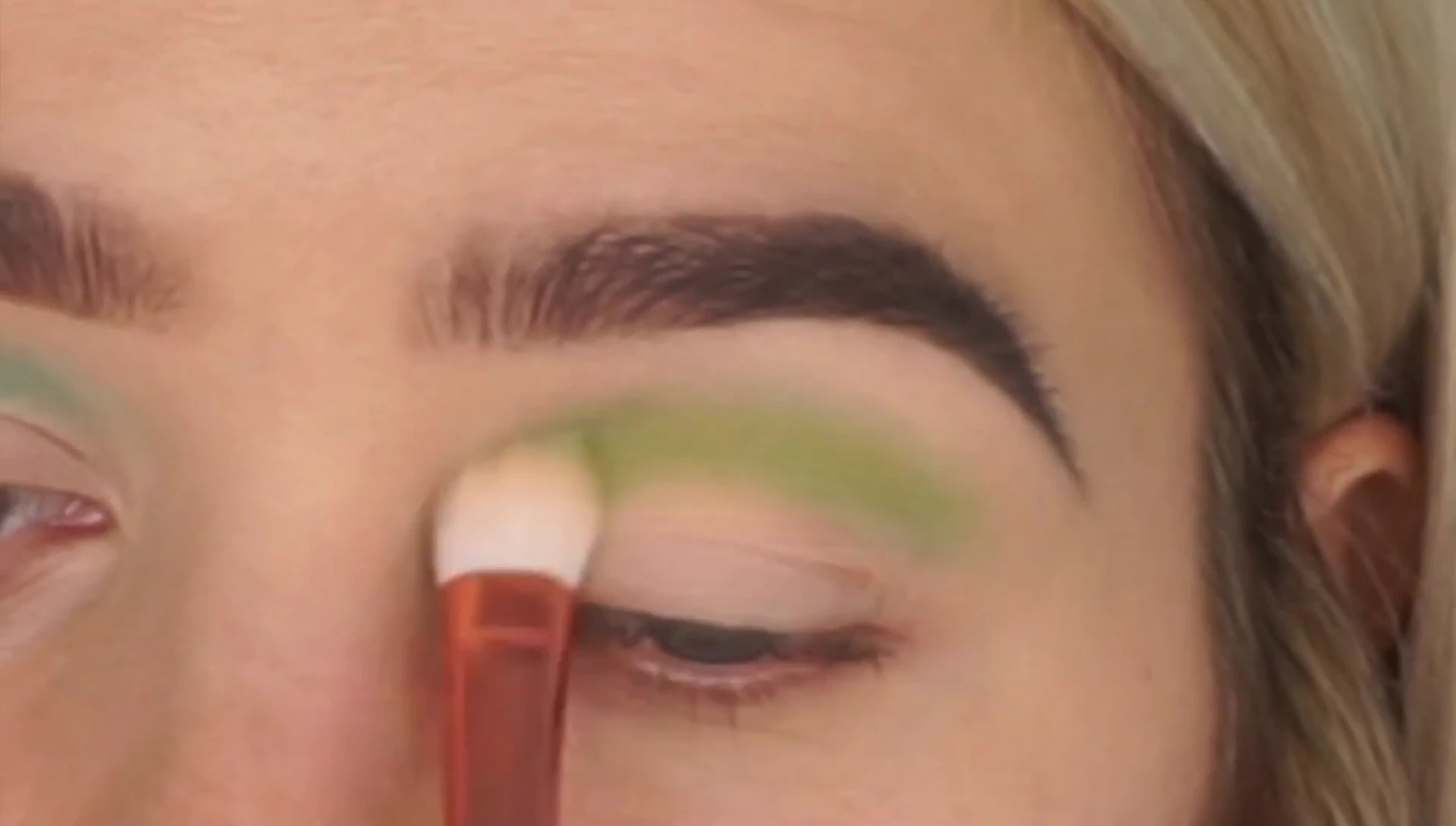 Using the crease brush to blend eyeshadow shades.