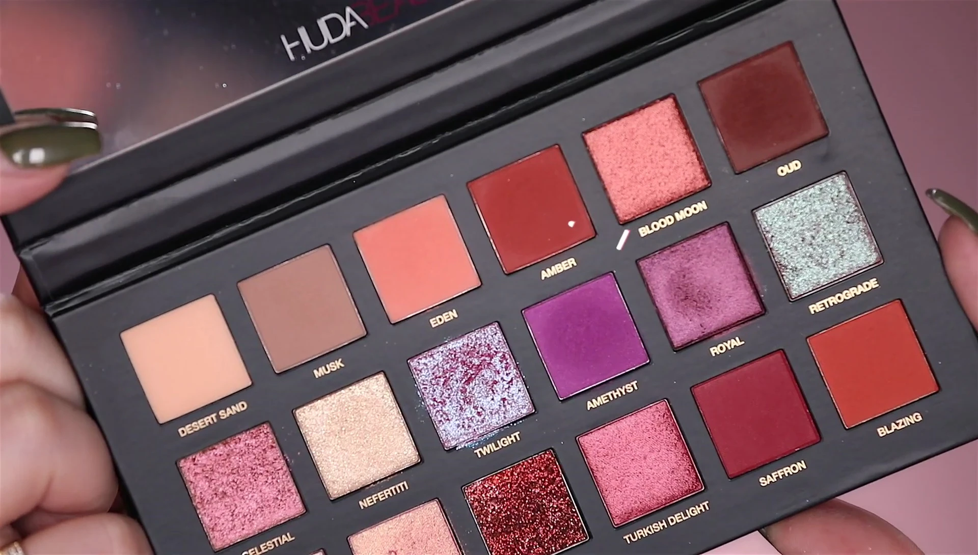 The reviewer using a brush to blend the eyeshadows