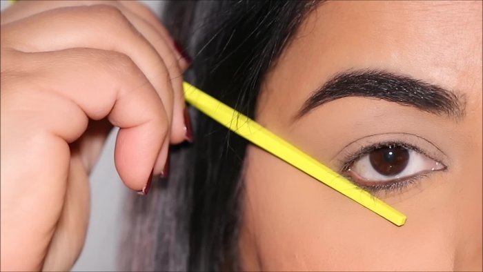 Apply sticky tape to the outer corner of your eye as an extension of your lower lash line, angling it upwards and outwards.