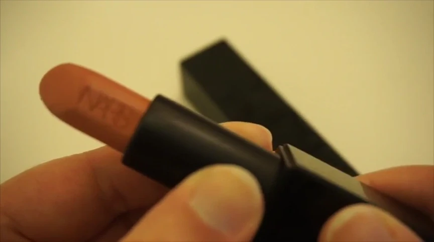 Close-up shot of the lipstick bullet with NARS engraved on it.