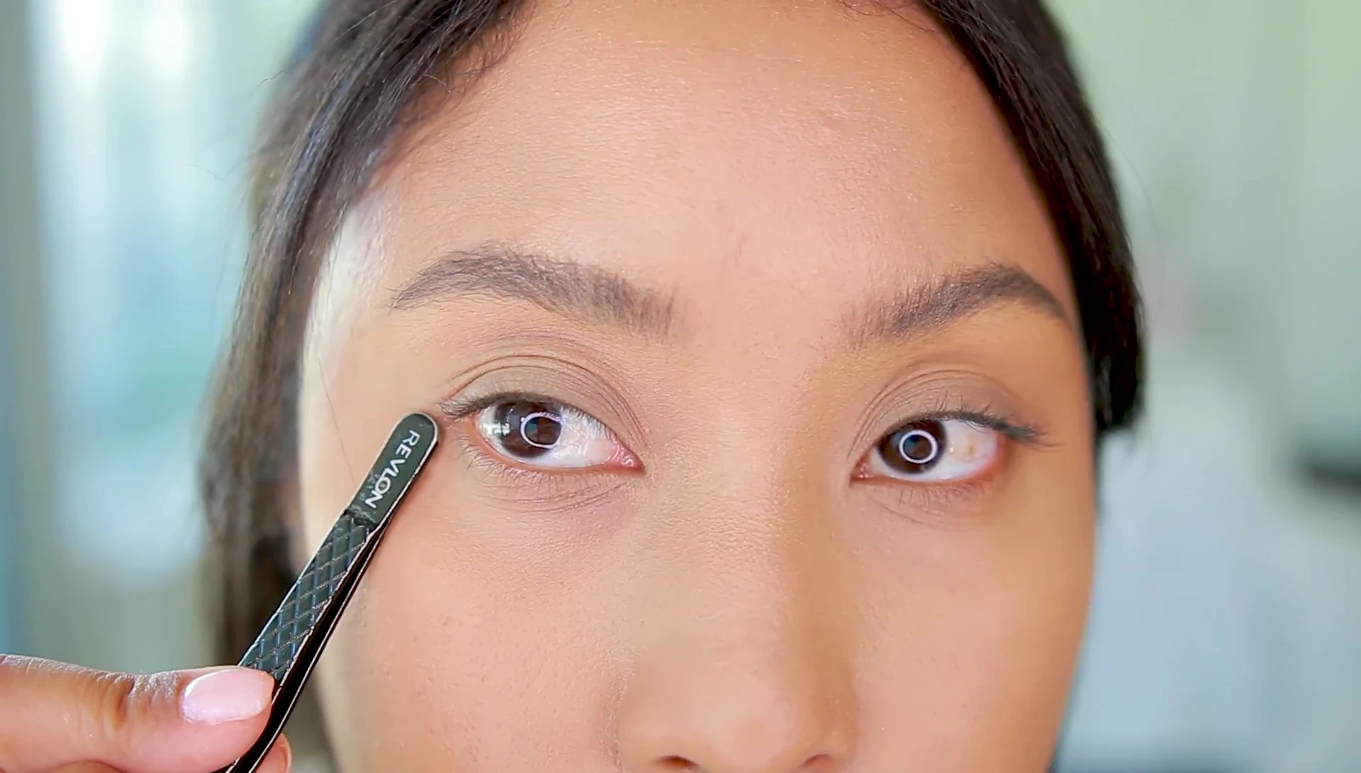 The YouTuber pointing out the crease of the hooded eyelid.