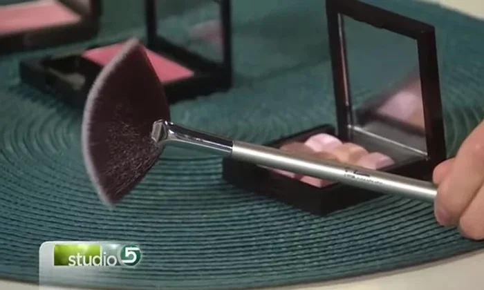 (Highlight) Use a fan brush to apply a highlighter underneath your eyes and sweep it upwards towards your temples.