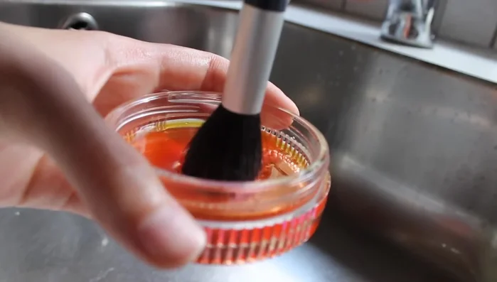 Swirl the brush on the lid and under running water.