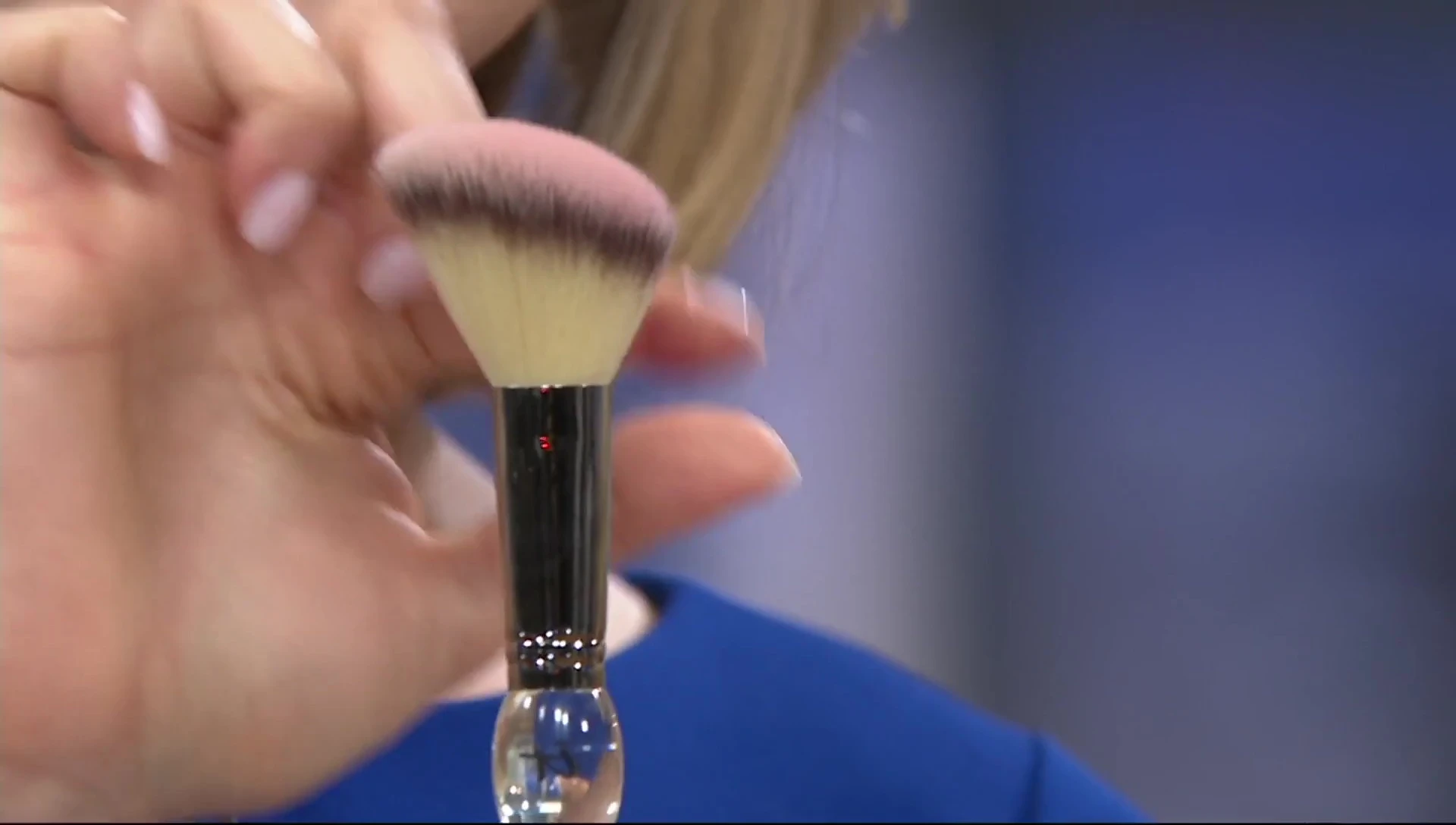 Demonstration of brush application on a model's cheek.