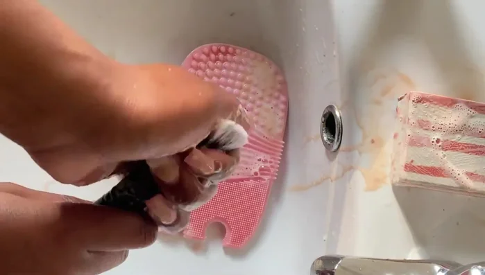 Rub brushes against the brush cleaning mat.