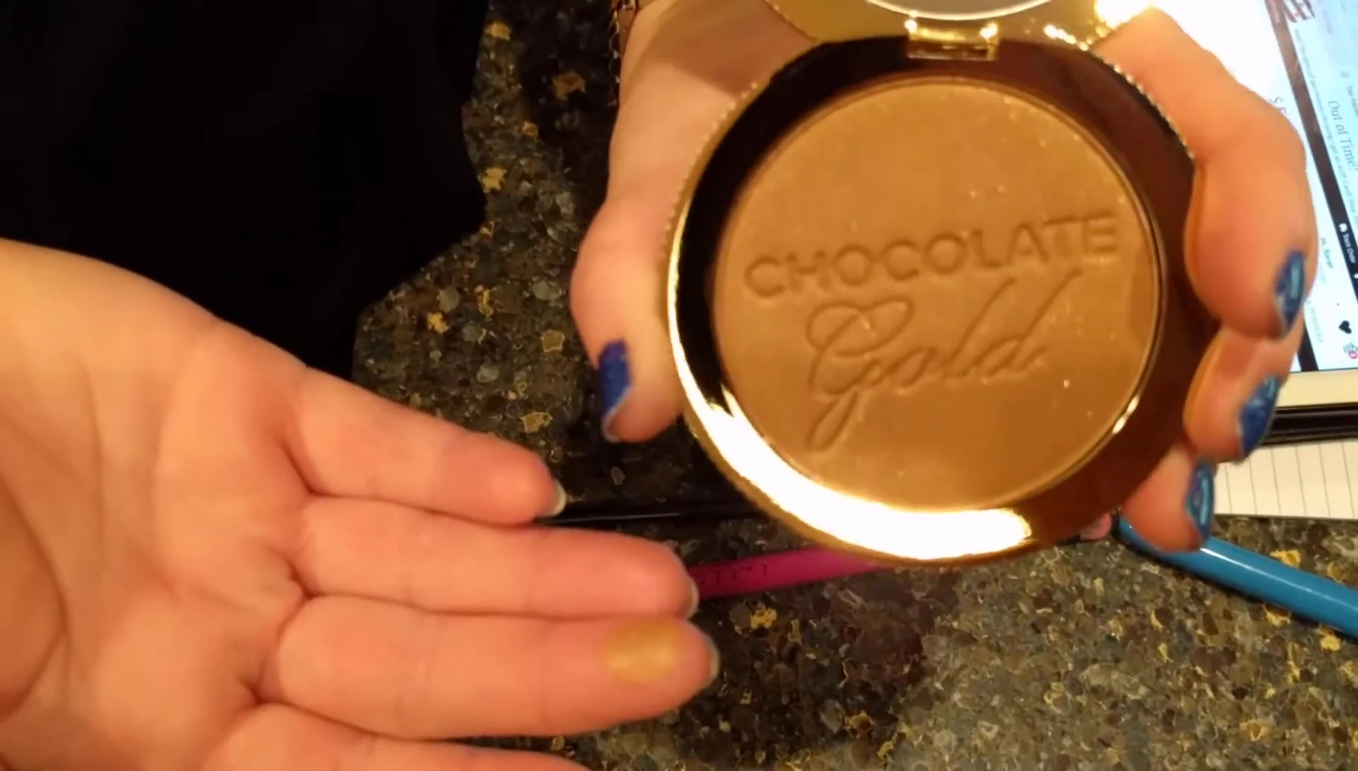The reviewer holding the bronzer, highlighting its packaging and size in relation to the price point.