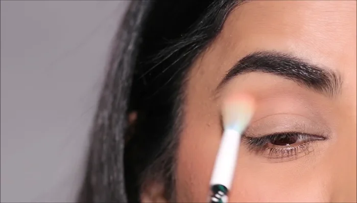 Apply the same darker shade to the lower lash line using a small angled brush, stamping it close to the lashes.
