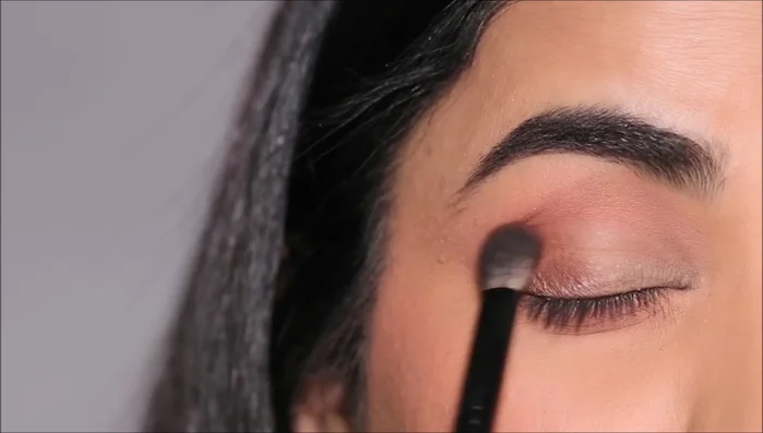 Apply the same darker shade to the lower lash line using a small angled brush, stamping it close to the lashes.