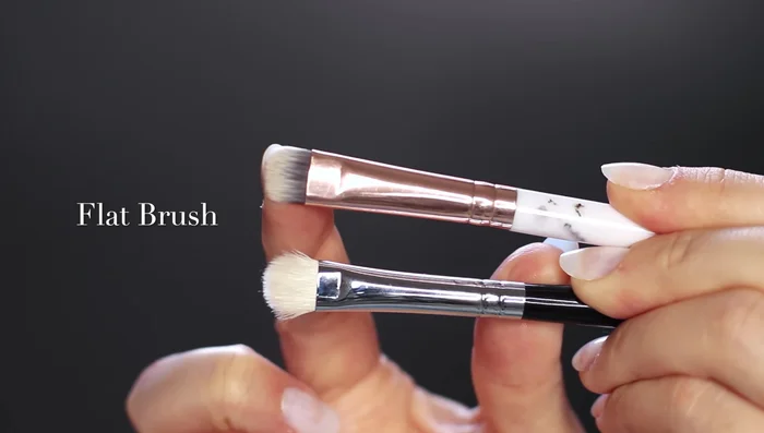 Use a fluffier flat brush to blend a contour shade (darker than your skin tone) around the edges of the black eyeshadow for a smooth fade. This also deepens the look.