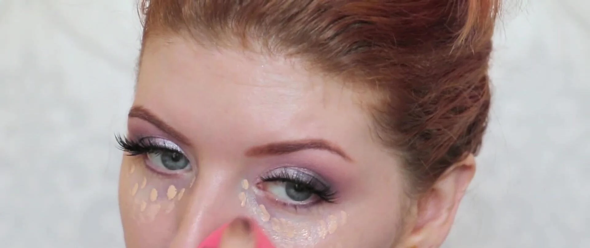 The reviewer applying concealer with the MAC sponge.