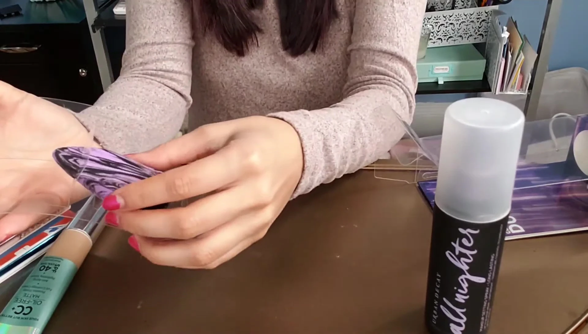 The reviewer holding the sponge showcasing its shape and marble design.