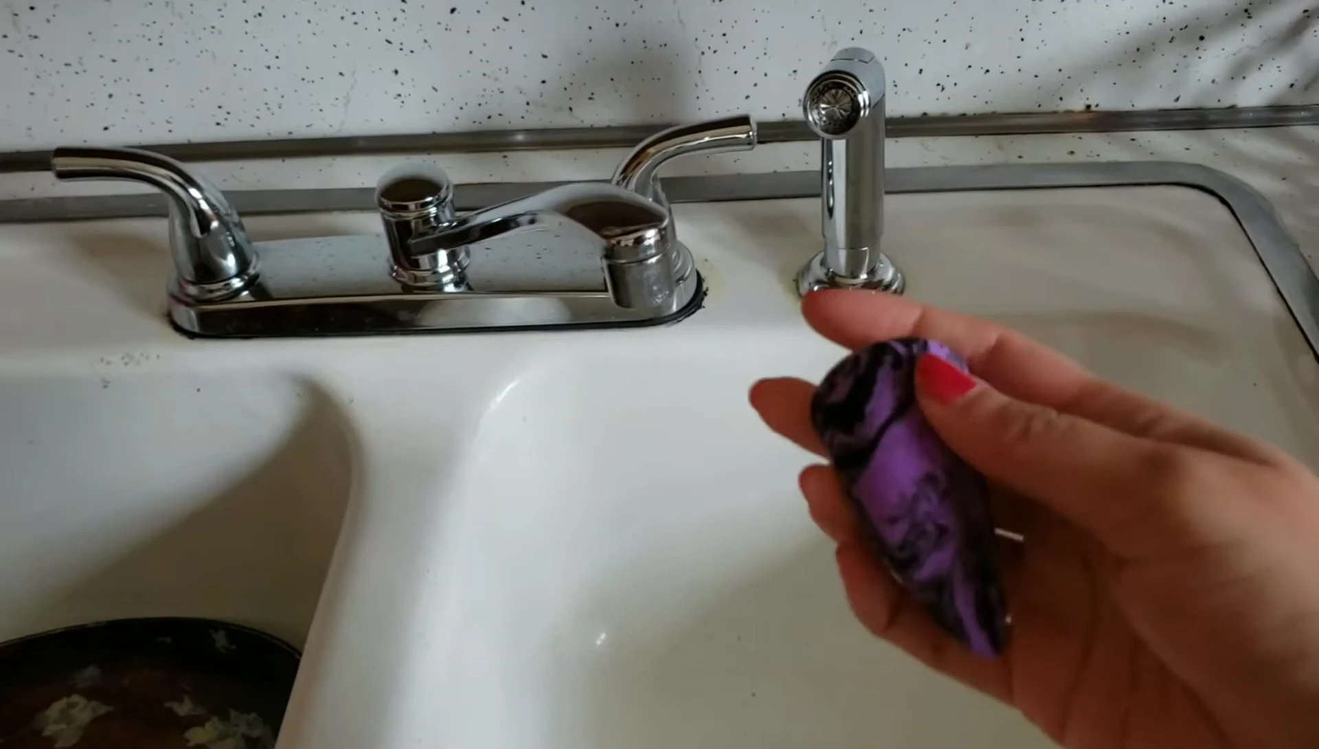 The reviewer dampening the sponge and spraying it with setting spray.