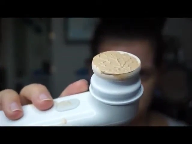 The speaker demonstrating foundation application with the sponge.