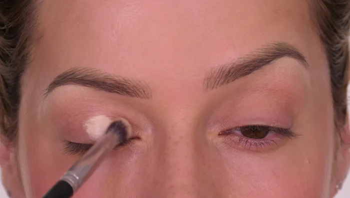 Apply a light powder eyeshadow (lighter than your skin tone) to the center of the lid, blending outwards slightly, to enhance the light area.