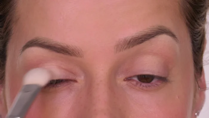 Apply a light powder eyeshadow (lighter than your skin tone) to the center of the lid, blending outwards slightly, to enhance the light area.